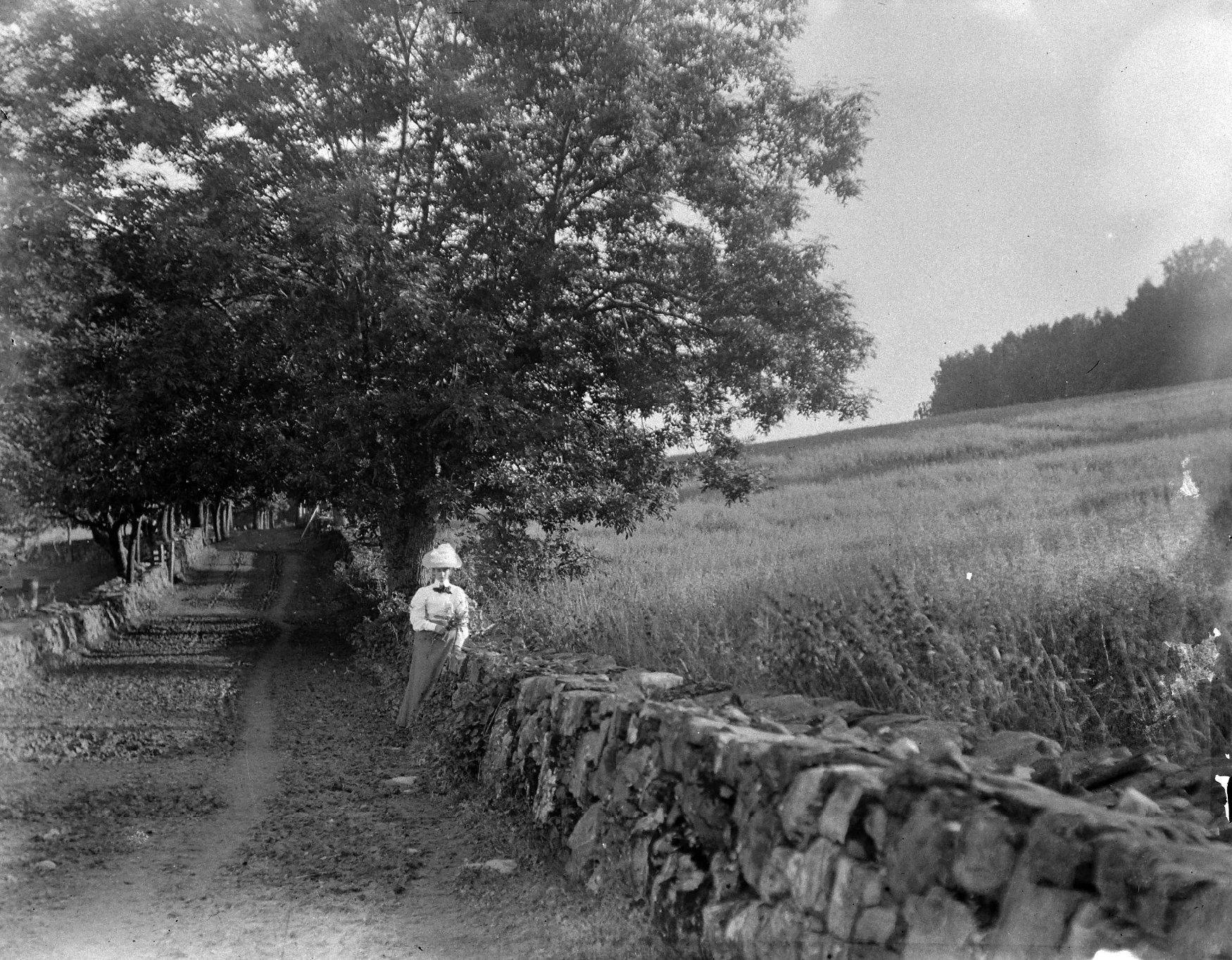 Woman by the stone wall